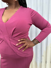 Load image into Gallery viewer, Closer view of the twist-front detail of a size 14 Cushnie berry mauve twist-front long sleeve midi dress with a front slit on a size 14/16 model. The photo was taken outside in natural lighting.