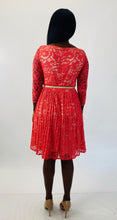 Load image into Gallery viewer, Full-body back view of a size 16 Eliza J coral lace long sleeve pleated midi dress with cream lining underneath and cream skinny belt styled with tan patent leather heels on a size 12 model.