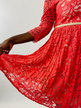 Load image into Gallery viewer, Close up detail shot of the pleated skirt, skinny cream belt, and sheer lace long sleeve details of this size 16 Eliza J coral lace pleated midi dress on a size 12 model.