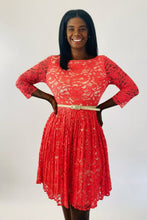 Load image into Gallery viewer, Front view of a size 16 Eliza J coral lace long sleeve pleated midi dress with cream lining underneath and cream skinny belt on a size 12 model.