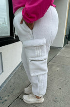 Load image into Gallery viewer, Side view of a size 2X Adidas x Ivy Park white furry drawstring joggers styled with a pink long sleeve tee and white sneakers on a size 18/20 model.