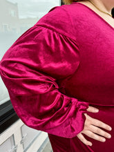 Load image into Gallery viewer, Close up view on the long puff sleeves with draped details of a size 22 Bloomchic deep red velvet mini dress with draped details and long, puff sleeves on a size 22/24 model. This photo is taken outside in natural lighting.