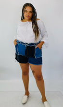 Load image into Gallery viewer, Size 4X SHEIN light and dark wash patchwork denim shorts with unfinished hems and distressing details styled with a white bell sleeve top and white slides on a size 18 model.