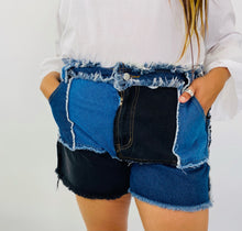 Load image into Gallery viewer, Size 4X SHEIN light and dark wash patchwork denim shorts with unfinished hems and distressing details on a size 18 model.