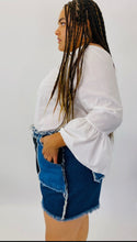 Load image into Gallery viewer, Side view of size 4X SHEIN light and dark wash patchwork denim shorts with unfinished hems and distressing details styled with a white bell sleeve top on a size 18 model.