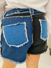 Load image into Gallery viewer, Back view of size 4X SHEIN light and dark wash patchwork denim shorts with unfinished hems and distressing details on a size 18 model.