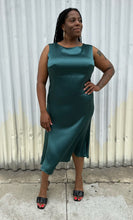 Load image into Gallery viewer, Full-body front view of a size 12/14 Henning deep teal silky sleeveless midi dress styled with black kitten heels on a size 14/16 model. The photo was taken outside in natural lighting.
