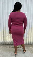 Load image into Gallery viewer, Full-body back view of a size 14 Cushnie berry mauve twist-front long sleeve midi dress with a front slit styled with black kitten heels on a size 14/16 model. The photo was taken outside in natural lighting.
