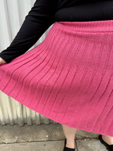Load image into Gallery viewer, Close up view of the knit pleats in this size 22/24 Eloquii bubblegum pink knit mini circle skirt on a size 22/24 model. The photo is taken outside in natural lighting.
