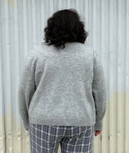 Load image into Gallery viewer, Back view of a size 22/24 Eloquii light gray cardigan with pearl &amp; gold buttons styled over a blue &amp; white plaid jumpsuit on a size 18/20 model. The photo was taken outside in natural lighting.
