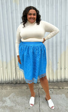 Load image into Gallery viewer, Full-body front view of a size 1/2X Beauciel bright baby blue circle skirt with lace overlay styled with a cream sweater and white mules on a size 18/20 model. The photo was taken outside in natural lighting.
