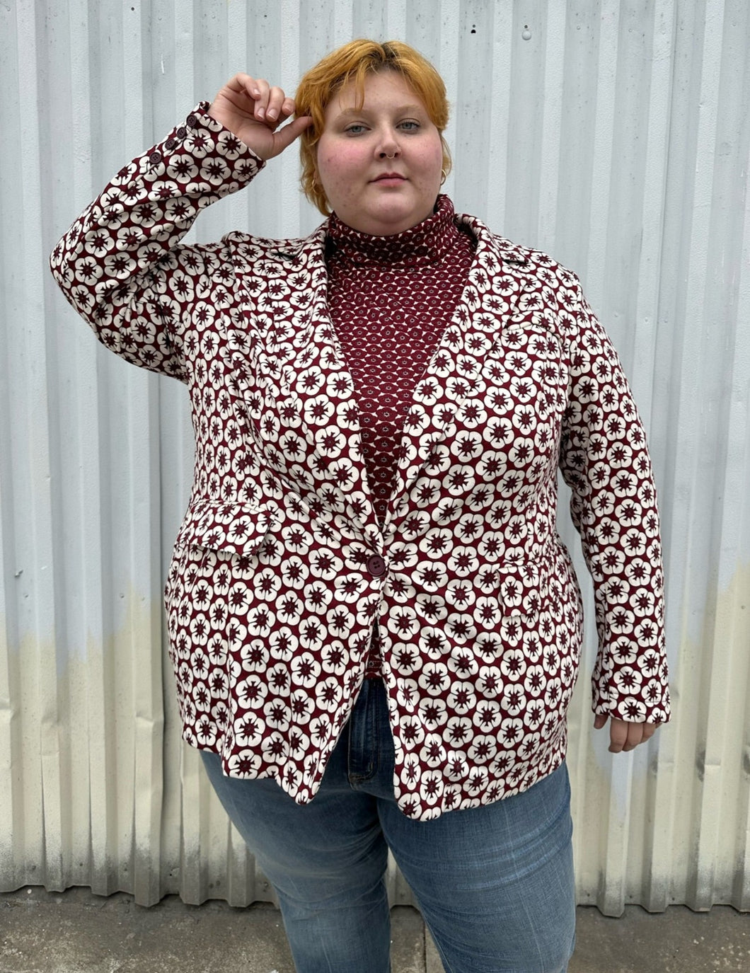 Front view of a size 4 Fashion to Figure x Gabi Fresh off-white and maroon 70s floral blazer with a single button closure styled over a turtleneck and lightwash denim on a size 22/24 model. The photo was taken outside in natural lighting.