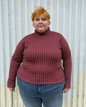 Load image into Gallery viewer, Front view of a size 4 Fashion to Figure x Gabi Fresh maroon &amp; off-white 70s floral turtleneck top styled over medium wash denim on a size 22/24 model. The photo is taken outside in natural lighting.

