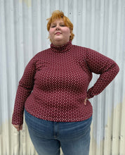 Load image into Gallery viewer, Additional front view of a size 4 Fashion to Figure x Gabi Fresh maroon &amp; off-white 70s floral turtleneck top styled over medium wash denim on a size 22/24 model. The photo is taken outside in natural lighting.
