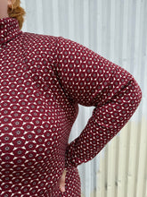 Load image into Gallery viewer, Close view of the 70s-inspired geometric floral pattern of a size 4 Fashion to Figure x Gabi Fresh maroon &amp; off-white 70s floral turtleneck top on a size 22/24 model. The photo is taken outside in natural lighting.
