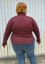 Load image into Gallery viewer, Back view of a size 4 Fashion to Figure x Gabi Fresh maroon &amp; off-white 70s floral turtleneck top styled over medium wash denim on a size 22/24 model. The photo is taken outside in natural lighting.
