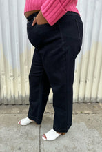 Load image into Gallery viewer, Side view of a pair of size 20 DC Jeans dark wash wide leg denim styled with a bubblegum pink cropped sweater and white mules on a size 18/20 model. The photo was taken outside in natural lighting.
