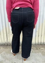 Load image into Gallery viewer, Back view of a pair of size 20 DC Jeans dark wash wide leg denim styled with a bubblegum pink cropped sweater and white mules on a size 18/20 model. The photo was taken outside in natural lighting.
