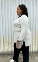 Load image into Gallery viewer, Side view of a size 18/20 Lane Bryant x Girl with Curves collab gray ribbed longline turtlneck sweater with brown faux fur cuffs styled with dark wash denim on a size 18/20 model. The photo was taken outside in natural lighting.
