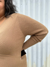 Load image into Gallery viewer, Close view of the ribbing on a size 18/20 Eloquii light brown ribbed faux wrap sweater on a size 18/20 model. The photo was taken outside in natural lighting.
