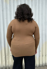 Load image into Gallery viewer, Back view of a size 18/20 Eloquii light brown ribbed faux wrap sweater styled over dark wash denim on a size 18/20 model. The photo was taken outside in natural lighting.
