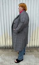 Load image into Gallery viewer, Full-body side view of a size 3X Nilli Lotan x Target black and white gingham double breasted longline peacoat styled closed over a pink sweater, medium wash denim, and black slides on a size 22/24 model. The photo was taken outside in natural lighting.
