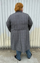 Load image into Gallery viewer, Full-body back view of a size 3X Nilli Lotan x Target black and white gingham double breasted longline peacoat styled closed over a pink sweater, medium wash denim, and black slides on a size 22/24 model. The photo was taken outside in natural lighting.
