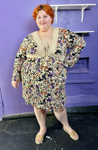 Load image into Gallery viewer, Additional full-body front view of a size 3 Torrid light tan, orange, purple, and black floral crochet embroidered detail 70s inspired long sleeve midi dress on a size 22/24 model. The photo was taken inside in flourescent and natural lighting.
