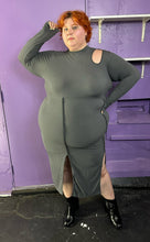 Load image into Gallery viewer, Full-body front view of a size 3X Finesse dark gray ribbed long sleeve midi dress with a shoulder cut out, two front slits, and contrast stitching details styled with patent leather black boots on a size 22/24 model. The photo was taken inside in flourescent and natural lighting.
