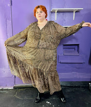 Load image into Gallery viewer, Additional full-body front view of a size 4X H&amp;M dark &amp; light brown and cream floral and paisley tiered maxi dress styled with black patent leather boots on a size 22/24 model. The photo was taken inside under flourescent and natural lighitng.
