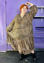Load image into Gallery viewer, Full-body front view of a size 4X H&amp;M dark &amp; light brown and cream floral and paisley tiered maxi dress styled with black patent leather boots on a size 22/24 model. The photo was taken inside under flourescent and natural lighitng.
