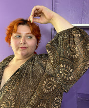 Load image into Gallery viewer, Close up view of the puff sleeves and gorgeous floral and paisley pattern of a size 4X H&amp;M dark &amp; light brown and cream floral and paisley tiered maxi dress styled with black patent leather boots on a size 22/24 model. The photo was taken inside under flourescent and natural lighitng.
