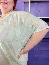 Load image into Gallery viewer, Close view of the dolman sleeves of a size XXL (fits up to 24 comfy) H&amp;M light green and white acid wash tie dye caftan on a size 22/24 model. The photo was taken inside under fluorescent and natural lighting.

