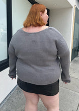 Load image into Gallery viewer, Back view of a a size 4X Wild Fable gray-brown v-neck knit sweater styled over a pleather mini skirt on a size 22/24 model. The photo is taken outside in natural lighting.
