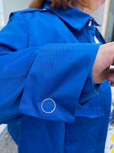 Load image into Gallery viewer, Close up view of the large, silver snap-closure buttons at the cuffs on a size 3X Target x Black History Month cobalt blue wind breaker with large silver snap-closure buttons on a size 22/24 model.
