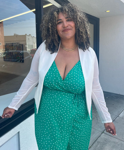 Front view of a size 0 Torrid white collarless blazer styled open over a kelly green wrap dress on a size 16/18 model.