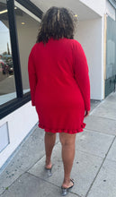 Load image into Gallery viewer, Full-body back view of a size 22 Pretty Little Thing red wrap mini dress with ruffles and tulip hem styled with black heels on a size 16/18 model. The photo is taken outside in natural lighting.
