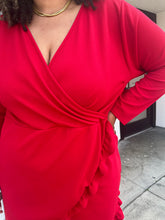Load image into Gallery viewer, Close up view of the v-neck and wrap detail with ruffles of a size 22 Pretty Little Thing red wrap mini dress with ruffles and tulip hem on a size 16/18 model.
