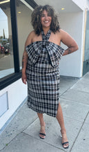 Load image into Gallery viewer, Full-body front view of a size 24 Eloquii black and white sequin plaid halter neckline with oversized bow detail at the bust styled with black and clear heels on a size 16/18 model.
