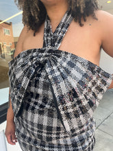 Load image into Gallery viewer, Close up view of the halter neckline and oversized bow bust of a size 24 Eloquii black and white sequin plaid halter neckline with oversized bow detail at the bust styled with black and clear heels on a size 16/18 model.
