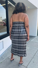 Load image into Gallery viewer, Full-body back view of a size 24 Eloquii black and white sequin plaid halter neckline with oversized bow detail at the bust styled with black and clear heels on a size 16/18 model.
