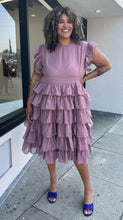 Load image into Gallery viewer, Full-body front view of a size 3X JessaKae mauve ruffle-tiered midi dress with burnout eyelet pattern and high neckline styled with bright purple heels on a size 16/18 model.
