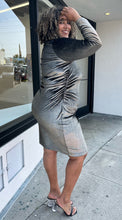Load image into Gallery viewer, Full-body side view of a size 2X Rachel Roy metallic brown-gold velvet long sleeve bodycon midi dress with ruching at the sides styled with black and clear heels on a size 16/18 model. The photo is taken outside in natural lighting.
