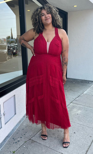Full-body front view of a size 20 City Chic red lace and mesh halter-style gown with a tan mesh bust panel styled with black and clear heels on a size 16/18 model. The photo is taken outside in natural lighting.