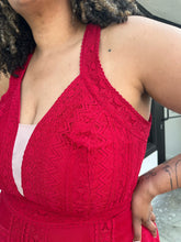 Load image into Gallery viewer, Close up view of the lace-over-mesh overlay pattern of a size 20 City Chic red lace and mesh halter-style gown with a tan mesh bust panel on a size 16/18 model. The photo is taken outside in natural lighting.
