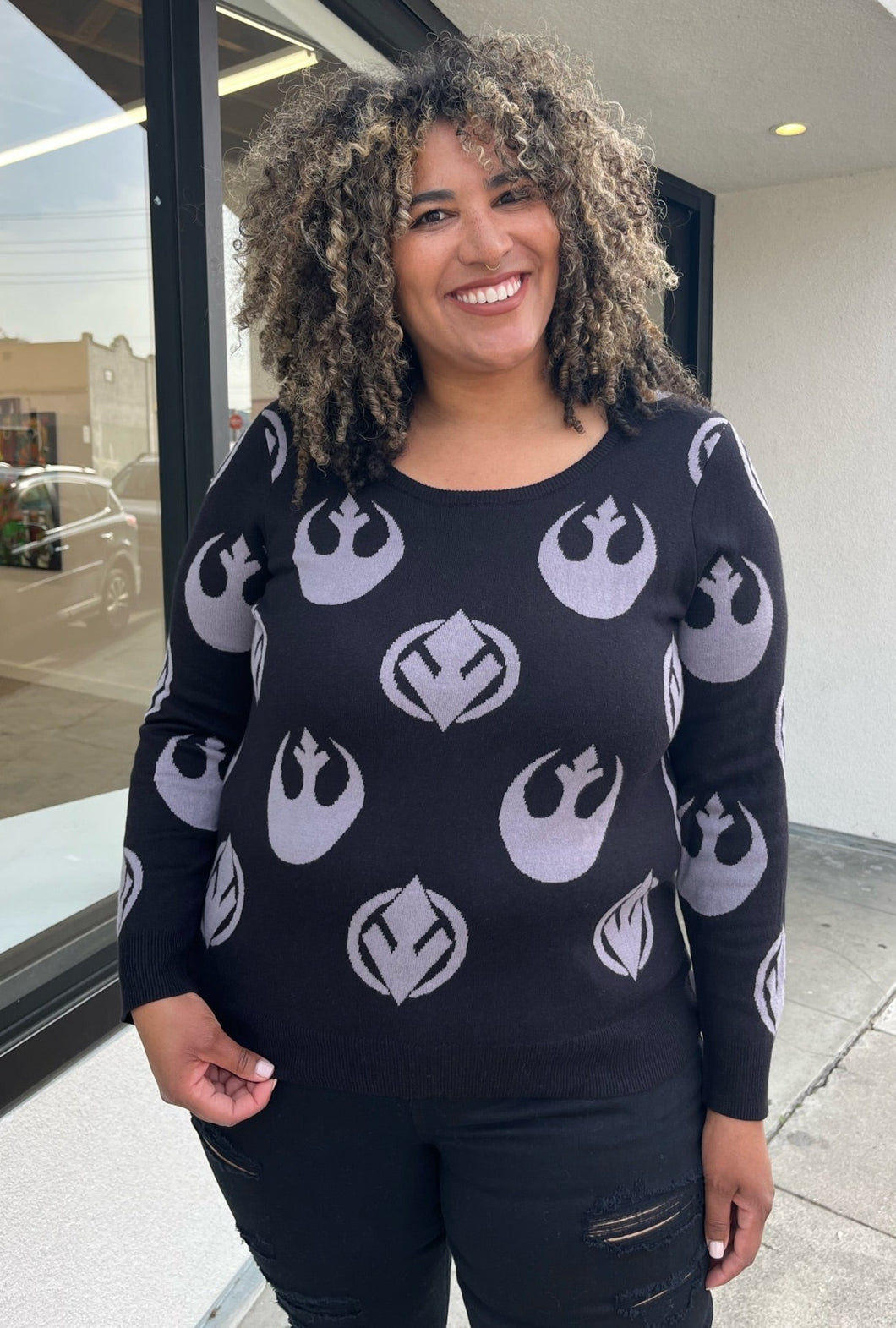 Front view of a size 2 Her Universal black and gray Star Wars Jedi and Rebel Alliance symbol sweater styled with black distressed jeans on a size 16/18 model. The photo is taken outside in natural lighting.
