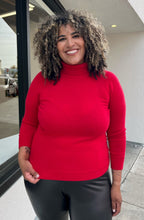 Load image into Gallery viewer, Front view of a size 1X Talbots red cashmere turtleneck sweater styled with black leather pants on a size 16/18 model. The photo is taken outside in natural lighting.
