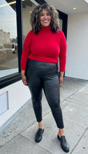 Load image into Gallery viewer, Front view of black Avex Les Filles Skinny Pants on a size 16/18 model. The pants have a thick waistband and the model is wearing a red turtleneck sweater with them.  
