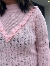 Load image into Gallery viewer, Up close view of a soft pink Eloquii sweater in a size 18/20 on a size 16/18 model. The photo shows the ruffle on the front of the sweater with the high neck. 
