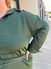 Load image into Gallery viewer, Close up view of the sheen of the material of a size 26 Eloquii emerald green maxi shirt dress with an o-ring fabric belt on a size 22/24 model. The photo is taken outside in natural lighting.
